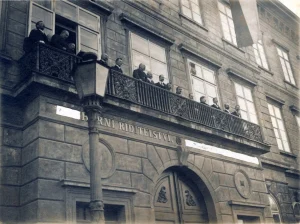 Lidé na balkoně budovy horního ředitelství v Příbrami na dobové fotografii